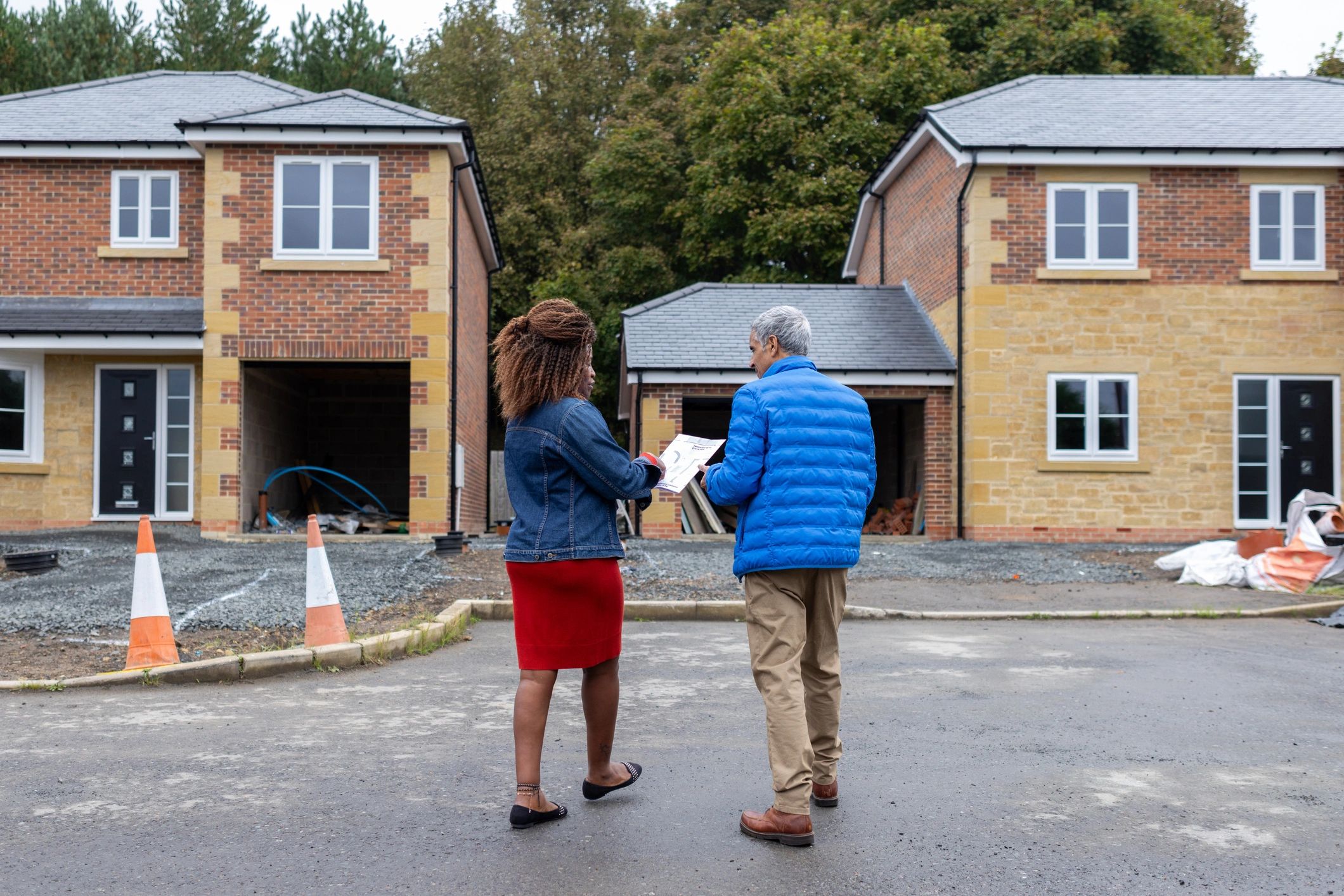 Real estate consultant discussing plans at a development site